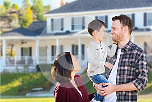 Young Mixed Race Caucasian and Chinese Family In Front of Custom Home