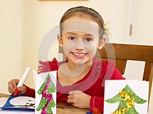 Young mixed race child making Christmas cards