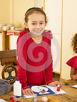 Young mixed race child making Christmas cards