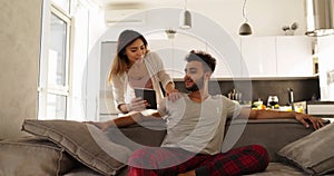 Young Mixed Race Couple Happy Hispanic Man Sit On Coach Asian Woman Using Tablet Computer Together