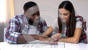Young mixed-race couple planning interior design of new house, relationship