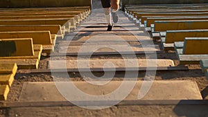 Young mixed race man runner in sport clothes running climbing up stairs in the stadium