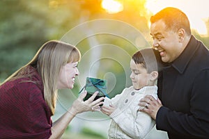 Young Mixed Race Son Handing Christmas Gift to His Mom