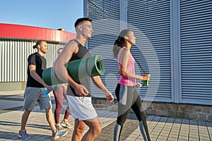 Young mixed race sportsmen with workout equipment