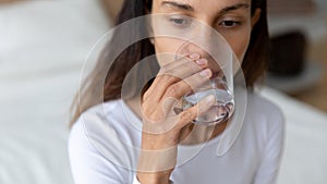 Young mixed race woman drinking glass of fresh pure water.