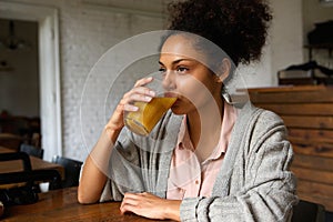 Young mixed race woman drinking orange juice