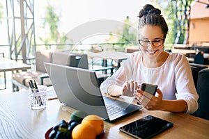 Young mixed race woman working with laptop in cafe at tropical location. Asian caucasian female studying using internet