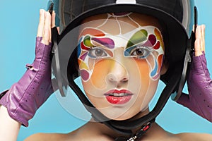Young model with bright creative make up with helmet