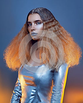 Young model posing in studio in silver clothes