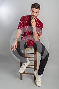 Young model with red shirt, piercings and fledgling beard