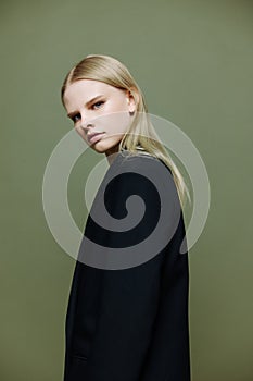 The young model turns and looks at the camera over her shoulder. Cool banner offer. A girl poses in isolation in a suit