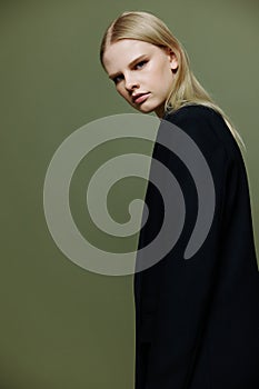 The young model turns and looks at the camera over her shoulder. Cool banner offer. A girl poses in isolation in a suit