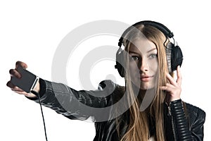 Young model in wired headphones is making selfie