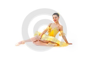 Young modern ballerina with yellow tutu doing the pose on white background