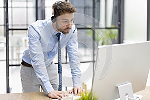 Young modern business man analyzing data using computer while working in the office.