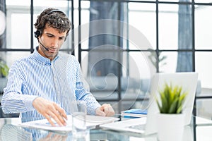 Young modern business man analyzing data using computer while working in the office.