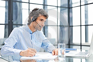 Young modern business man analyzing data using computer while working in the office.