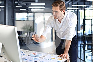 Young modern business man analyzing data using computer while working in the office.