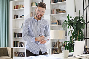 Young modern business man analyzing data using laptop while working in the office