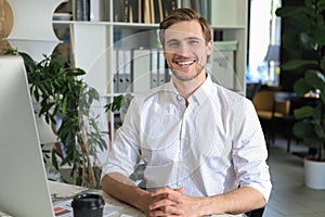 Young modern business man working using computer while sitting in the office.