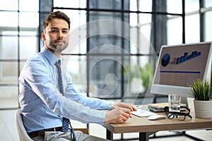 Young modern business man working using computer while sitting in the office.