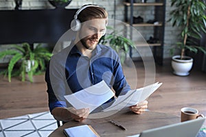 Young modern business man working using laptop while sitting in the home office