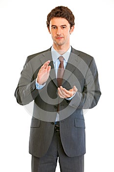 Young modern businessman cheerfully applauding