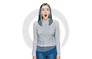 Young modern girl wearing casual sweater afraid and shocked with surprise expression, fear and excited face