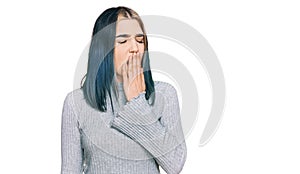 Young modern girl wearing casual sweater bored yawning tired covering mouth with hand
