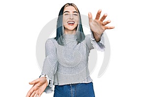 Young modern girl wearing casual sweater looking at the camera smiling with open arms for hug