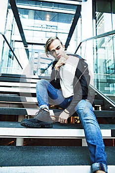 young modern hipster guy at new building university blond fashio