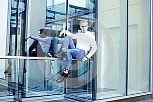 Young modern hipster guy at new building university blond fashion hairstyle having fun, lifestyle people concept