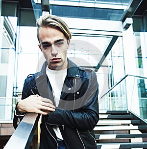 Young modern hipster guy at new building university blond fashion handsome boy, lifestyle people concept