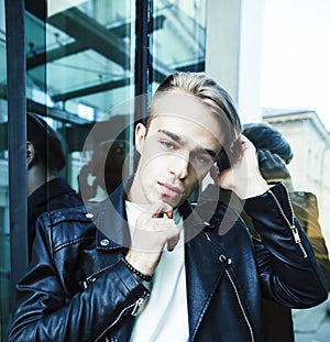 Young modern hipster guy at new building university blond fashion handsome boy, lifestyle people concept