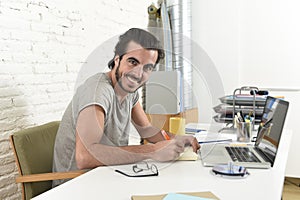 Young modern hipster style student or businessman working with laptop at home office