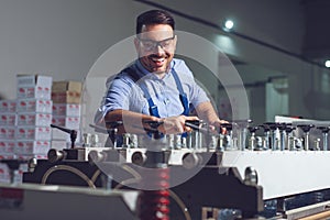 Modern industrial machine operator working in factory. Worker on the machine