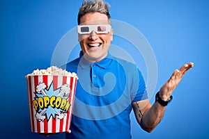 Young modern man watching cinema movie wearing 3d glasses and eating popcorn very happy and excited, winner expression celebrating