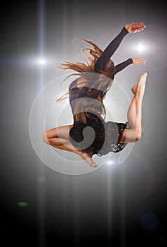 Young modern style dancer jumping in studio