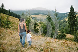 Young mom with baby boy travelling. Mother on hiking adventure with child, family trip in mountains. National Park. Hike with