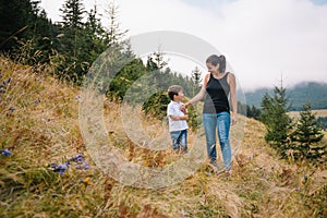 Young mom with baby boy travelling. Mother on hiking adventure with child, family trip in mountains. National Park. Hike