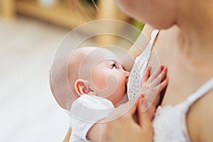 Young mom breast feeding her newborn child. Lactation infant concept. Mother feed her baby son or daughter with breast milk