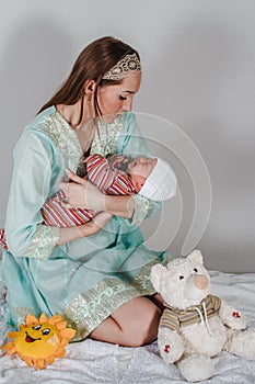 Young mom holding a newborn baby on her hands