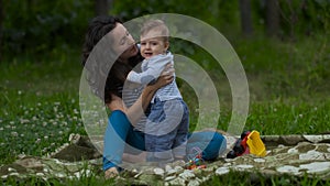 Young Mom with Little Baby Play in Garden.