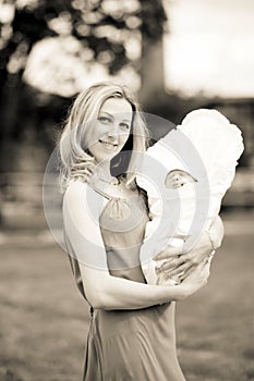 Young mom with a newborn baby outdoors