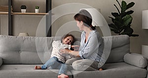 Young mom play with daughter tickling her laughing feels happy