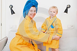 Young mom and son laughing on the couch after taking a bath