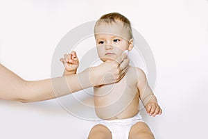 Young mom wiping the baby skin body and face with wet wipes carefully on white background. concept cleaning wipe, pure