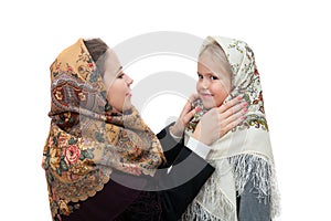 Young mother adjusts her shawl on the head daughter