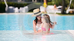 Young mother applying sun cream to daughter nose