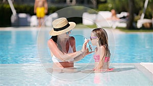 Young mother applying sun cream to daughter nose